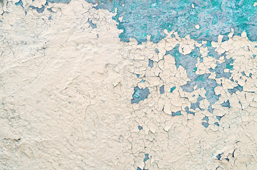 Peeling painted concrete wall, cracks of blue and beige, peeling paint of the old rough concrete wall, peeling paint texture